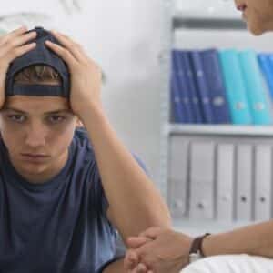 Depressed teenage boy during session with psychologist for Challenging Behaviours in Youth workshop